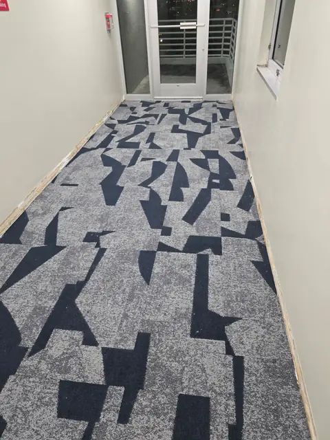 Patterned commercial carpet tile running to a corridor exit door