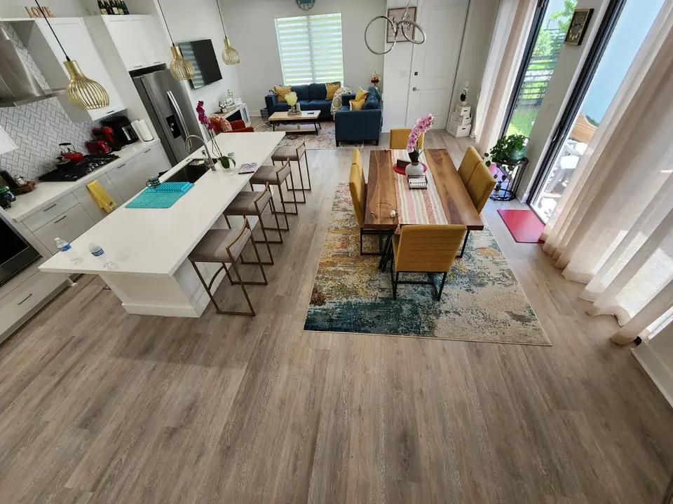 Open kitchen, dining and living area with light oak luxury vinyl plank flooring