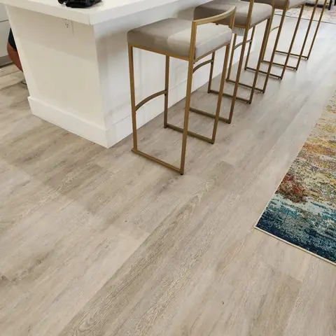 Bar stools at a kitchen island on light oak luxury vinyl plank