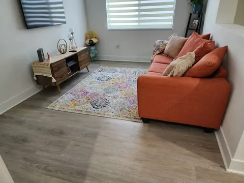 Living room with new light oak LVP and fresh baseboards