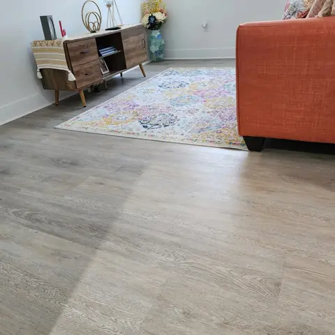 Living room LVP installation beneath a sofa and area rug