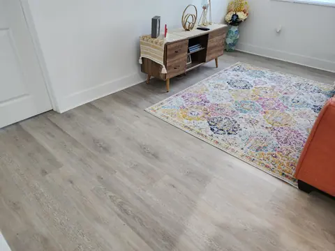 Living room with light oak vinyl plank and an area rug