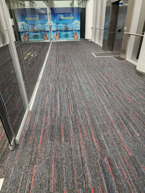 Glass-walled concourse corridor at MIA with finished carpet tile