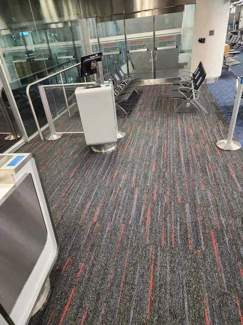 Carpet tile installed around a gate podium and stanchions at Miami International Airport