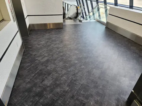 Dark gray carpet tile installed beside an escalator at Miami International Airport