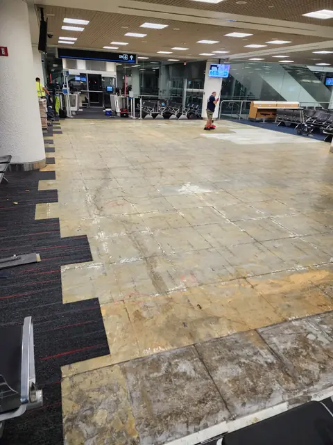 New carpet tile meeting the prepared substrate during installation
