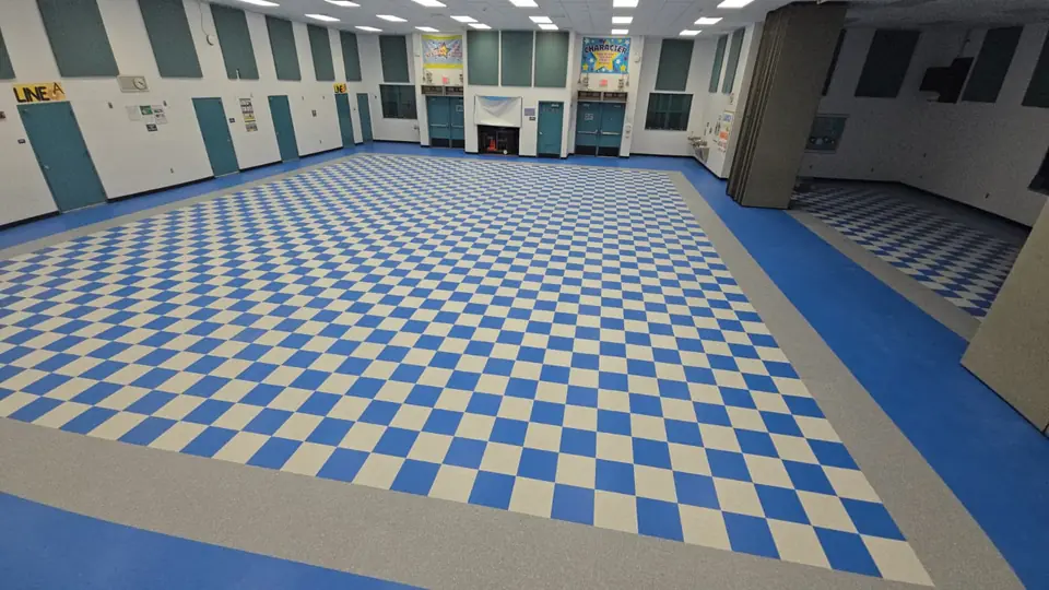 Blue and white checkerboard VCT with a gray border in a school cafeteria