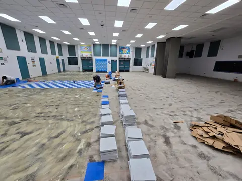 VCT installation in progress with tile stacks staged across the floor
